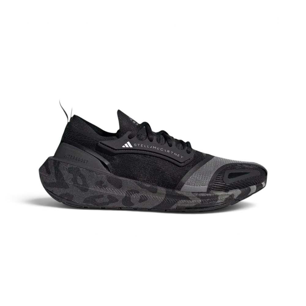Side profile of the black and white Stella McCartney Ultraboost, showing the sleek PRIMEKNIT upper and the thick Light BOOST midsole.