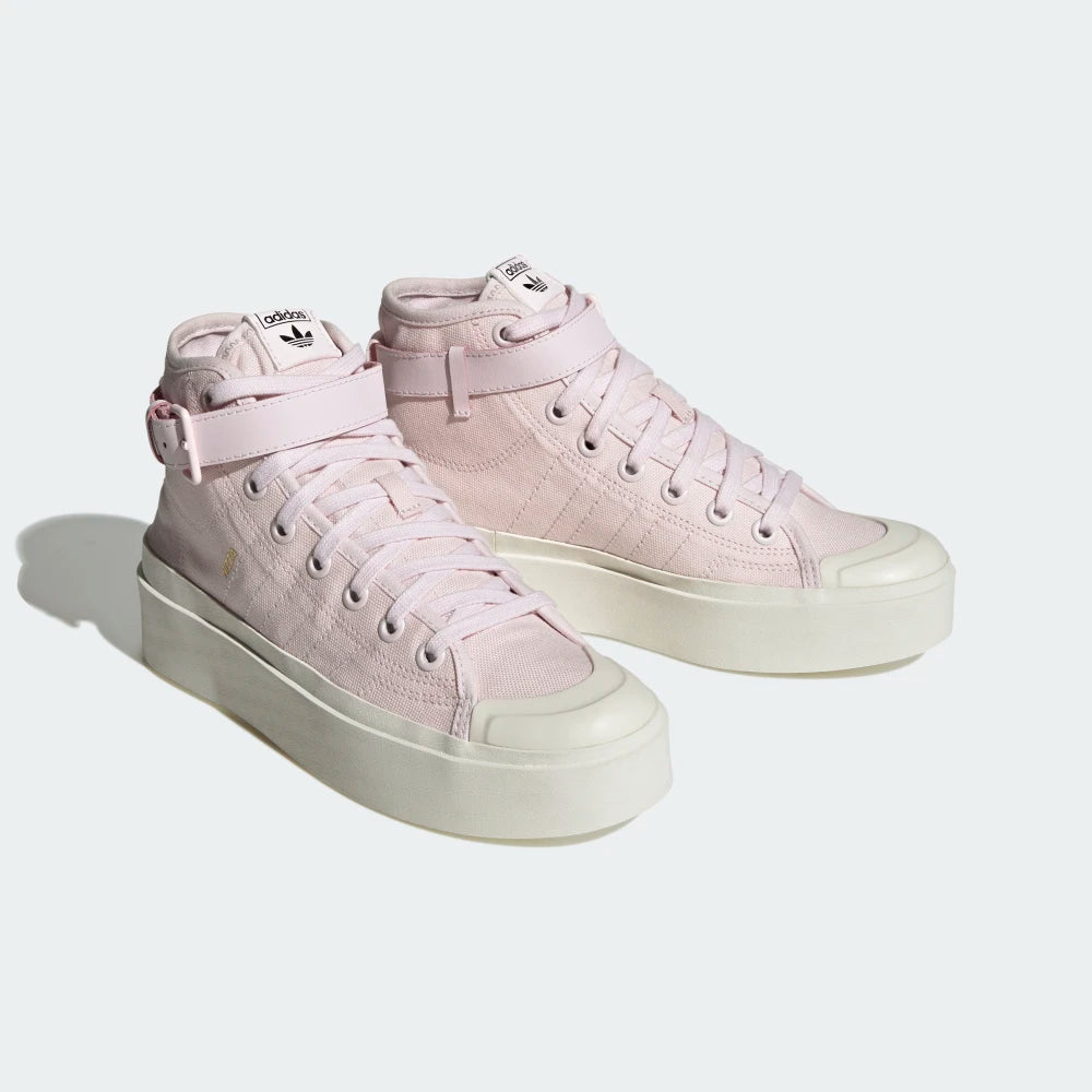 Emphasising the elevated, chunky retro basketball stance and the professional harmony of the pastel pink canvas panels resting against the thick platform base.