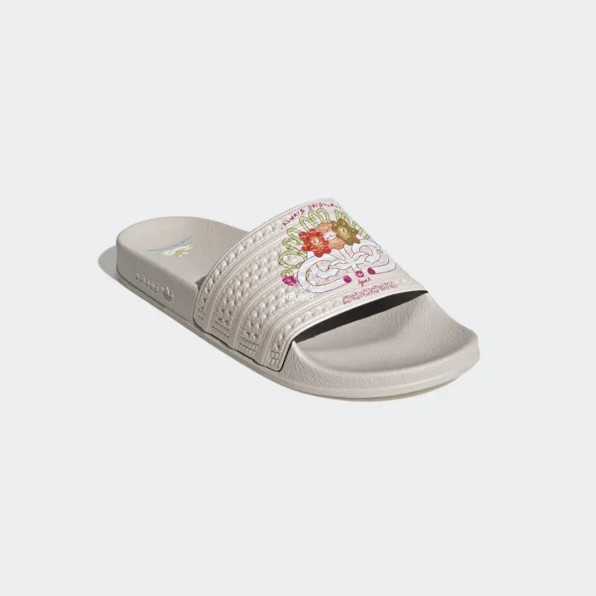 Close-up zoom on the strap of the Adidas Adilette Slides Unisex in pink, showing the classic three white stripes and the material texture.