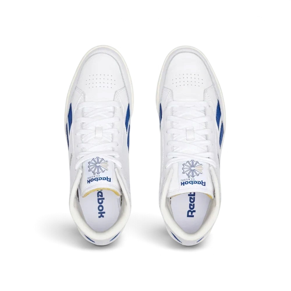 Top-down view of the white leather trainers, highlighting the exposed foam tongue and the clean, traditional lacing system.