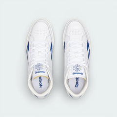 Top-down view of the white leather trainers, highlighting the exposed foam tongue and the clean, traditional lacing system.