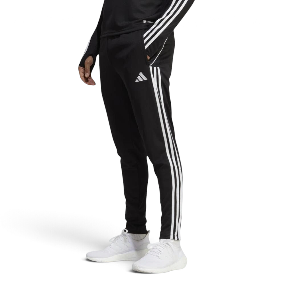 Side profile of the black Adidas Tiro 23 training pants, showcasing the slim tapered fit and the iconic white Three Stripes.