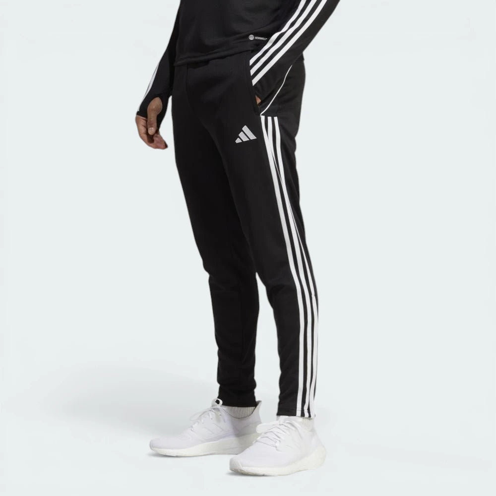 Side profile of the black Adidas Tiro 23 training pants, showcasing the slim tapered fit and the iconic white Three Stripes.