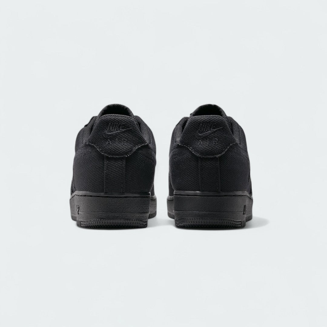 Rear view of the Nike Air Force 1 Low Canvas Men's black trainers, focusing on the heel panel and Nike Air branding.