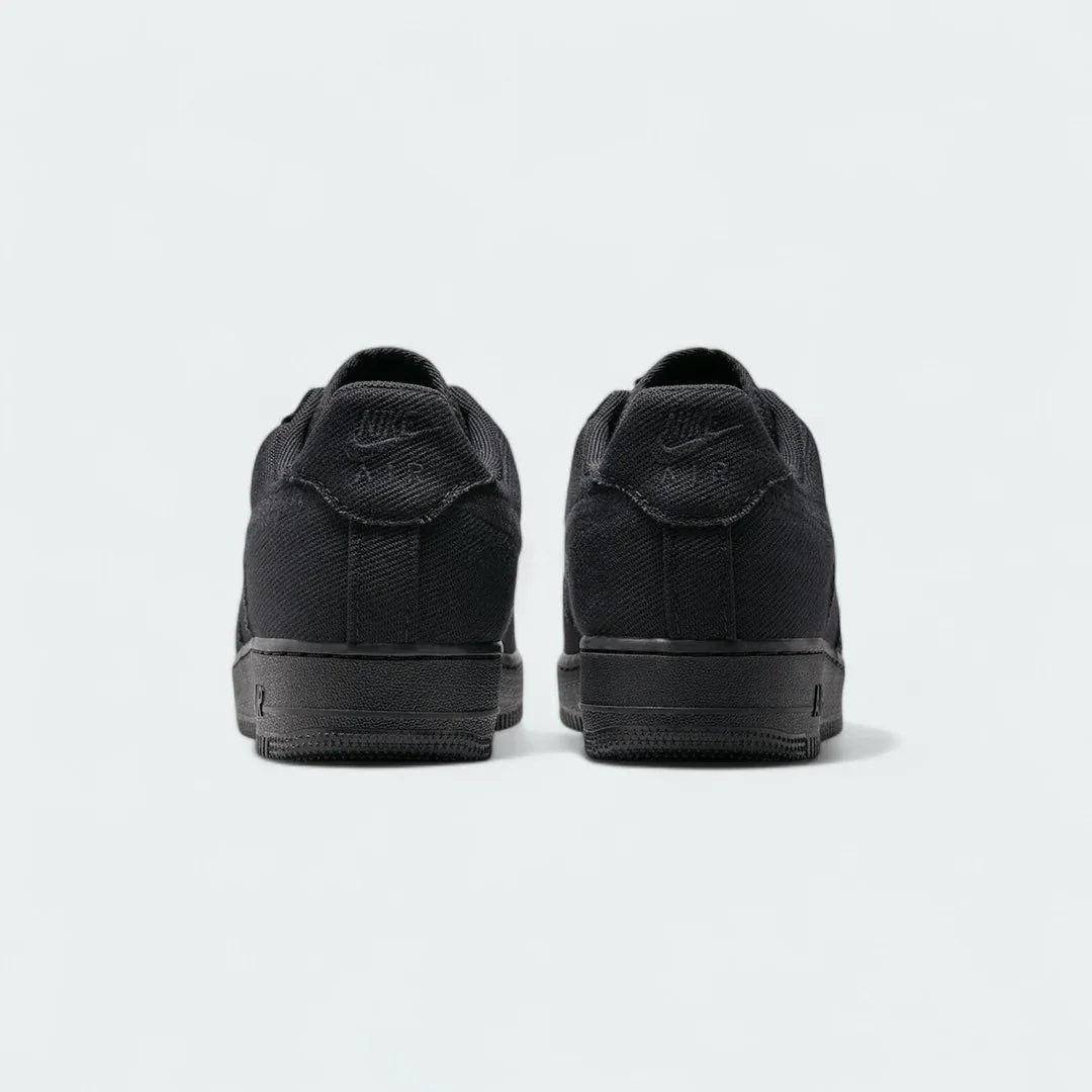 Rear view of the Nike Air Force 1 Low Canvas Men's black trainers, focusing on the heel panel and Nike Air branding.
