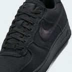 Close-up zoom on the front of the Nike Air Force 1 Low Canvas Men's trainers, showing the canvas upper texture, perforated toe box, and lacing system.