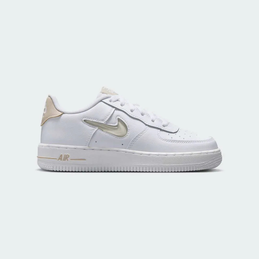 Nike Air Force 1 Low Juniors' trainers in white and sand colors, side profile showing classic leather upper, perforated toe box, and Nike Swoosh. Main image