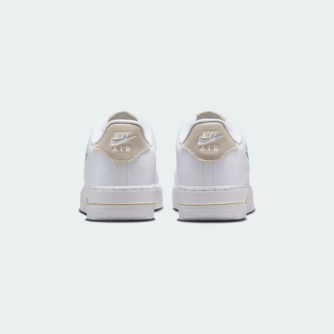 Rear view of the Nike Air Force 1 Low Juniors' white/sand trainers, focusing on the heel panel and Nike Air branding.