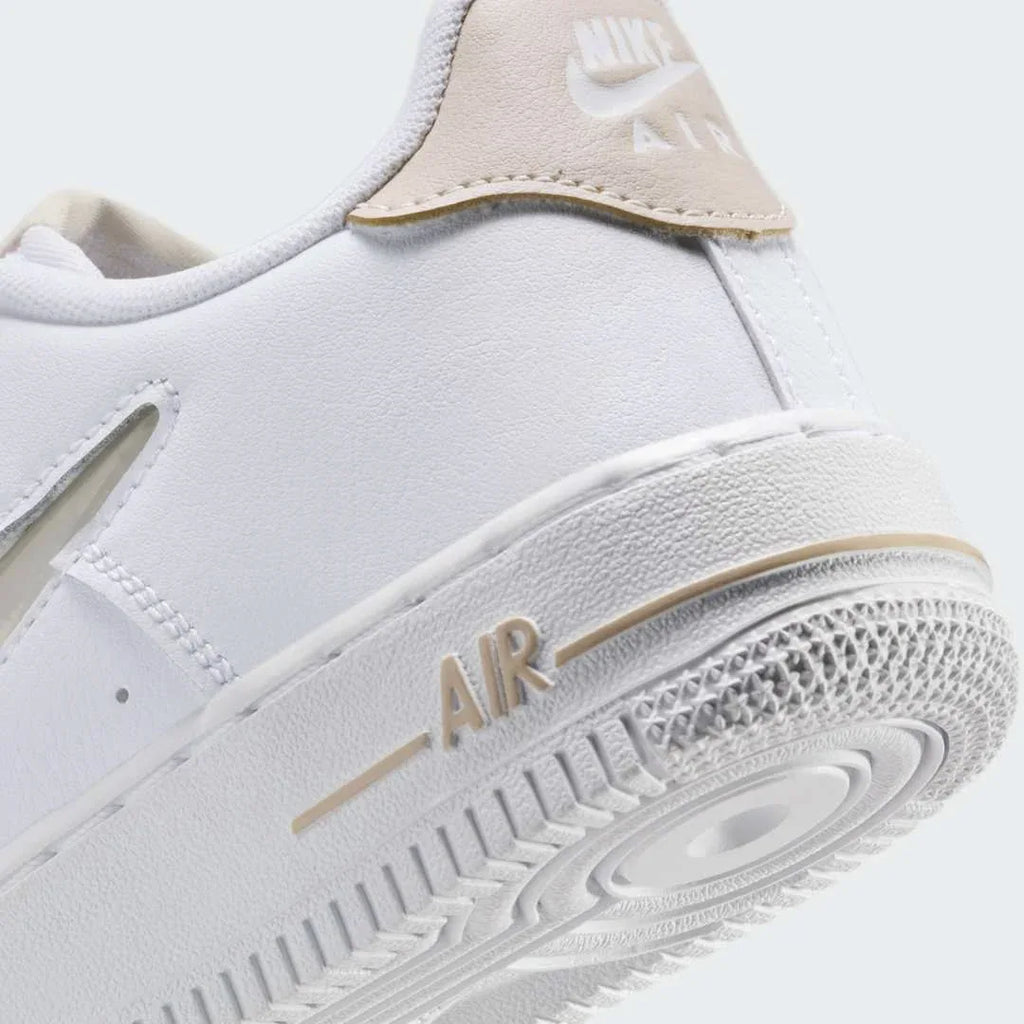 Detailed zoom on the outsole and midsole of the Nike Air Force 1 Low Juniors' white/sand trainers, highlighting the cushioned midsole and durable rubber outsole.