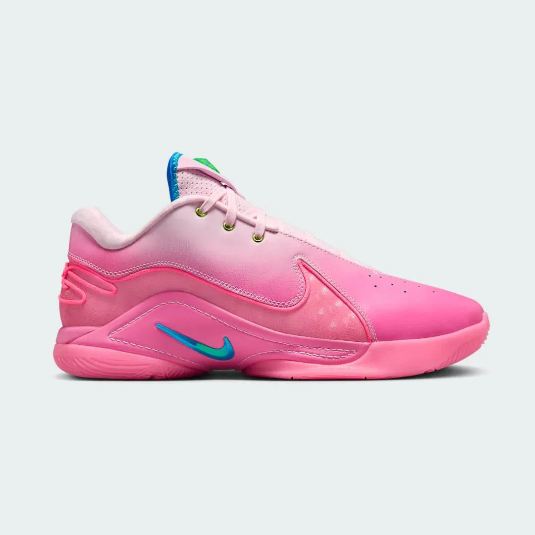 Nike LeBron XXII SN men's basketball trainer in pink foam/photo blue, side profile showing streamlined design, prominent Swoosh, and midfoot support wings. Main image