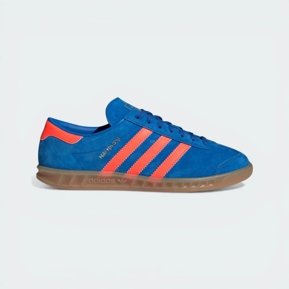 Side Profile Image: The Blue Bird Hamburg, highlighting the Solar Orange 3-Stripes and the iconic translucent gum sole.