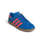 Emphasising the clean, streamlined low-top stance of the trainers and the brilliant colour contrast between the deep royal-blue suede chassis and luminous orange branding panels.
