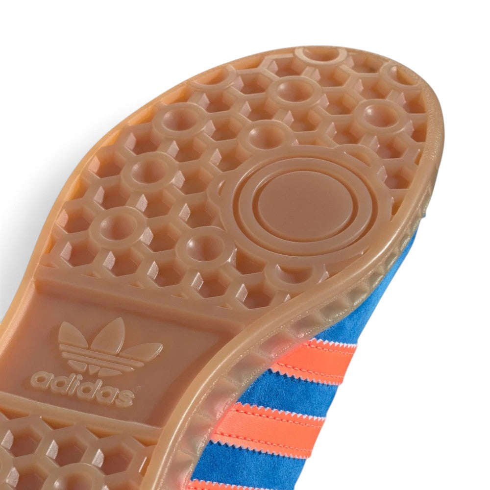 Highlights the "unreal" clean finish of the tread architecture, showing the recessed circular pivot point, raised honeycomb suction pods, and debossed adidas lettering along the gum cupsole border.