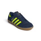 Emphasising the clean, streamlined low-top stance of the trainers and the brilliant colour contrast between the deep night-indigo suede chassis and luminous yellow branding panels.