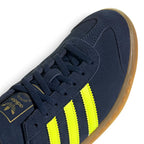 Details the micro-precision of the forefoot and lacing area, showing the double-stitched T-toe overlay, flat tonal laces, eyelet facings, and the gold foil Trefoil tongue crest.