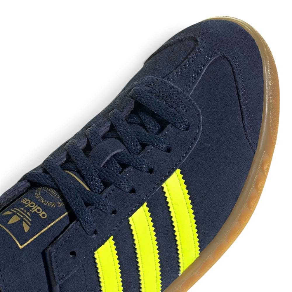 Details the micro-precision of the forefoot and lacing area, showing the double-stitched T-toe overlay, flat tonal laces, eyelet facings, and the gold foil Trefoil tongue crest.