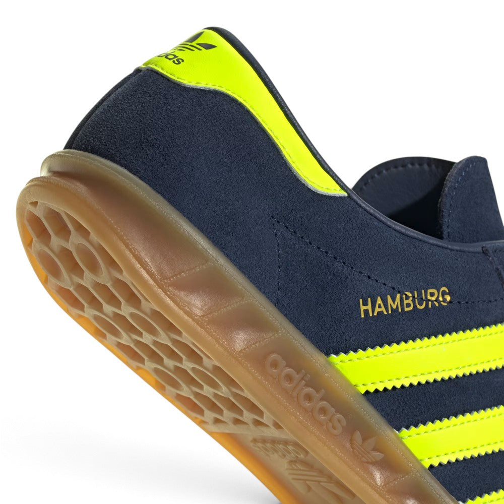 Highlights the clean finish of the tread architecture, showing the recessed circular pivot point, raised honeycomb suction pods, and debossed adidas lettering along the gum cupsole border.