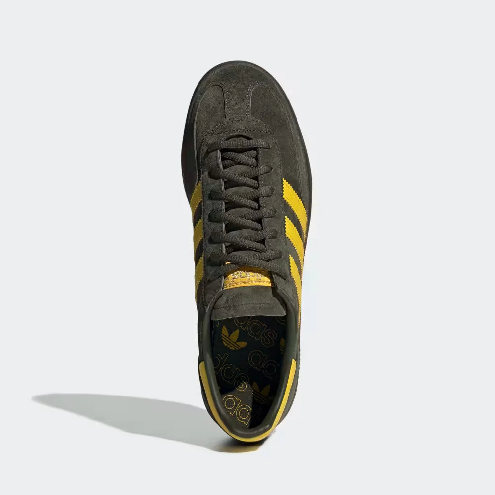 Looking down at the cargo green suede lacing system and the high-contrast yellow branding on the tongue.