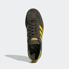 Looking down at the cargo green suede lacing system and the high-contrast yellow branding on the tongue.