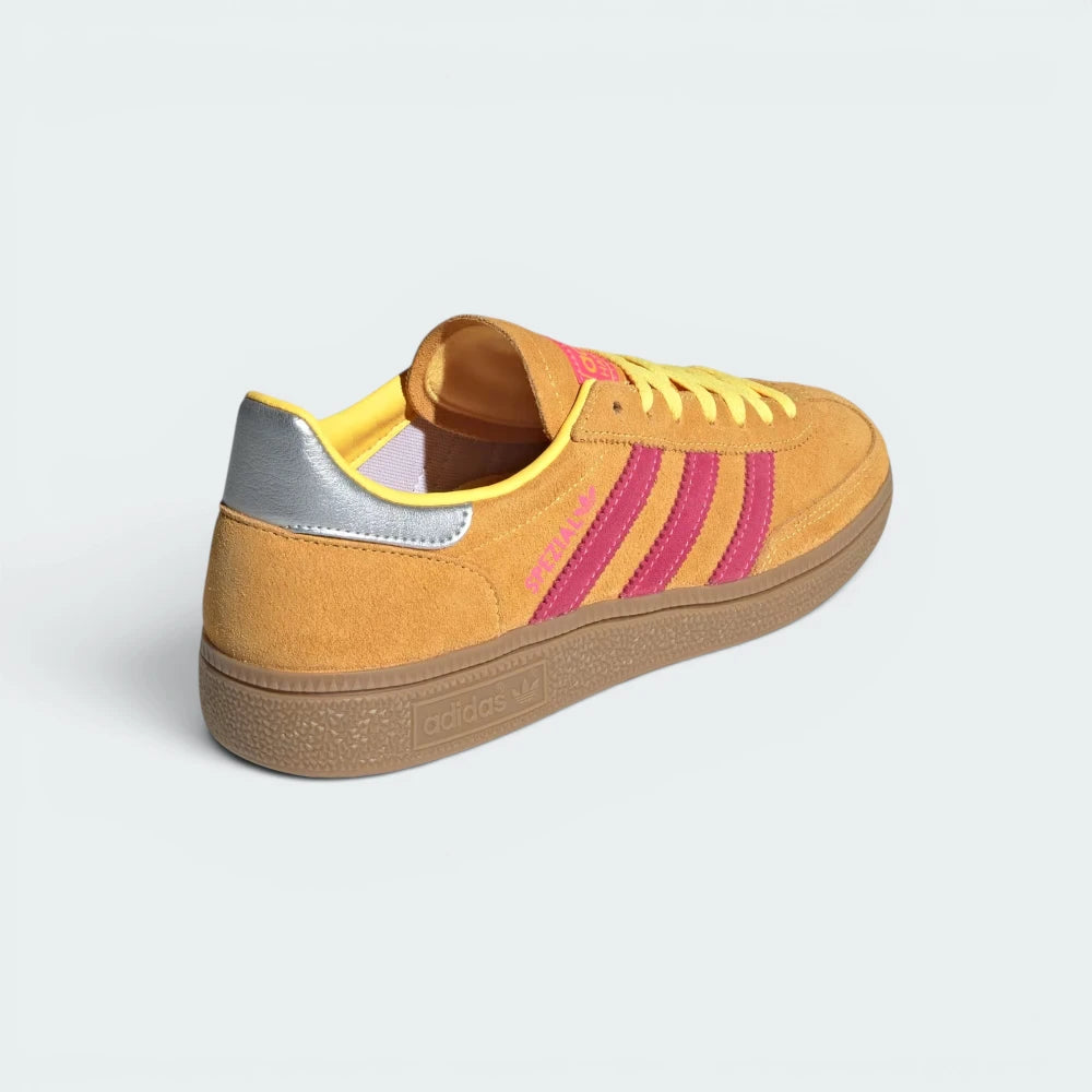 Focuses on the contoured shape of the pink leather heel counter and the clean, stitched finish of the low-profile rubber sole.