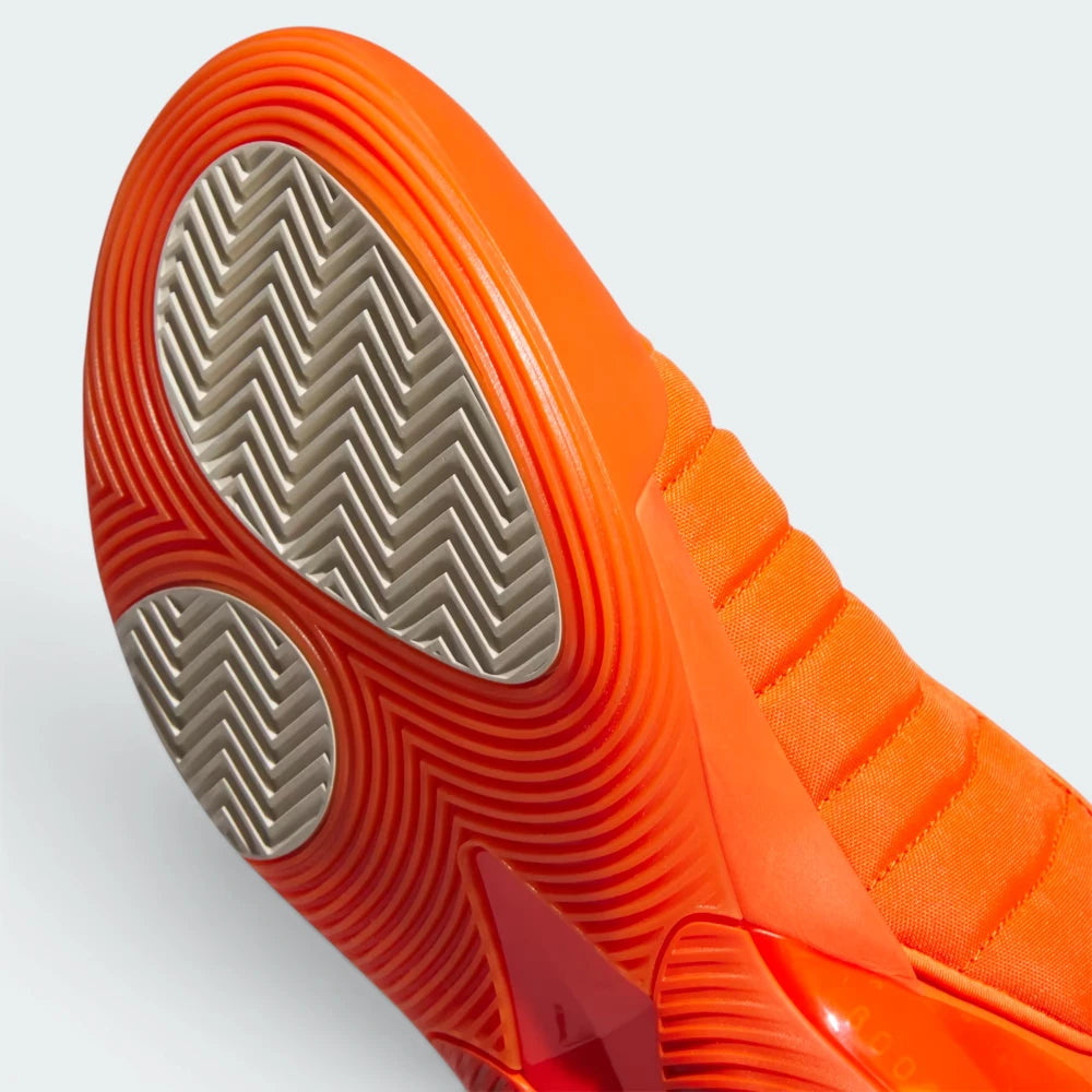 Close-up of an orange athletic shoe with a textured sole on a white background