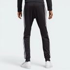 Focuses on the clean, uninterrupted fall of the black interlock fabric and the professional taper down to the ribbed cuffs.