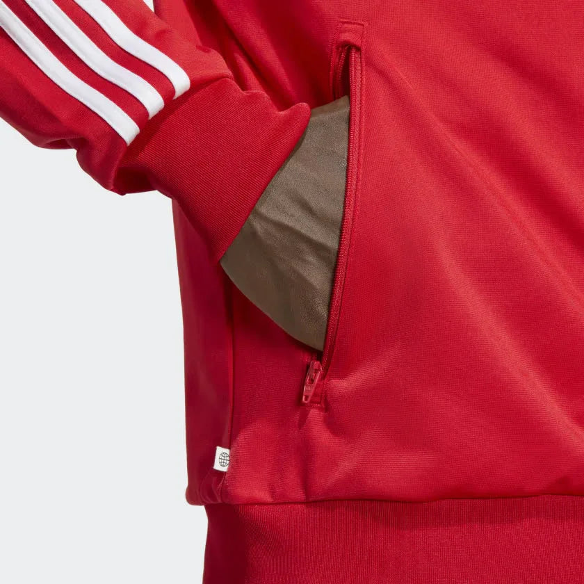 Firebird red jacket model demonstrating the zipped pocket and tag that shows recycled material