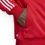 Firebird red jacket model demonstrating the zipped pocket and tag that shows recycled material