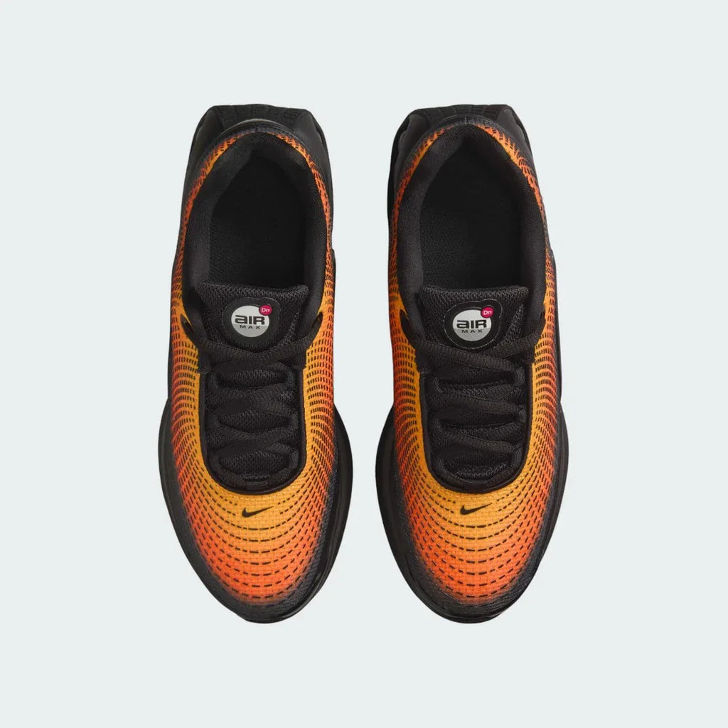 Top-down view of a pair of Nike Air Max DN Juniors' running trainers in black, highlighting their futuristic design and lace-up closure.