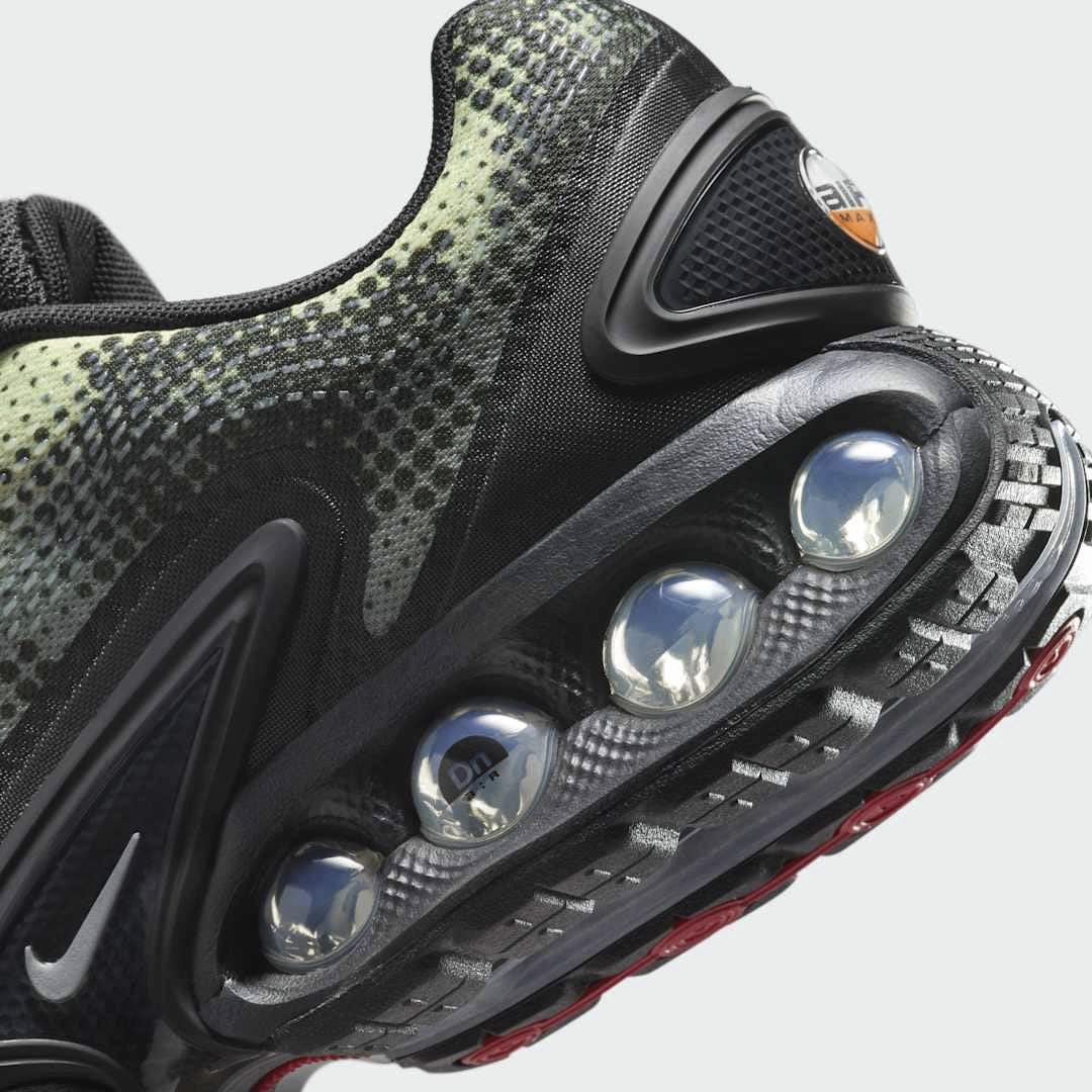 Detailed zoom on the outsole and midsole of the Nike Air Max DN Men's black running shoes, highlighting the dual-pressure Dynamic Air cushioning system and robust rubber outsole.