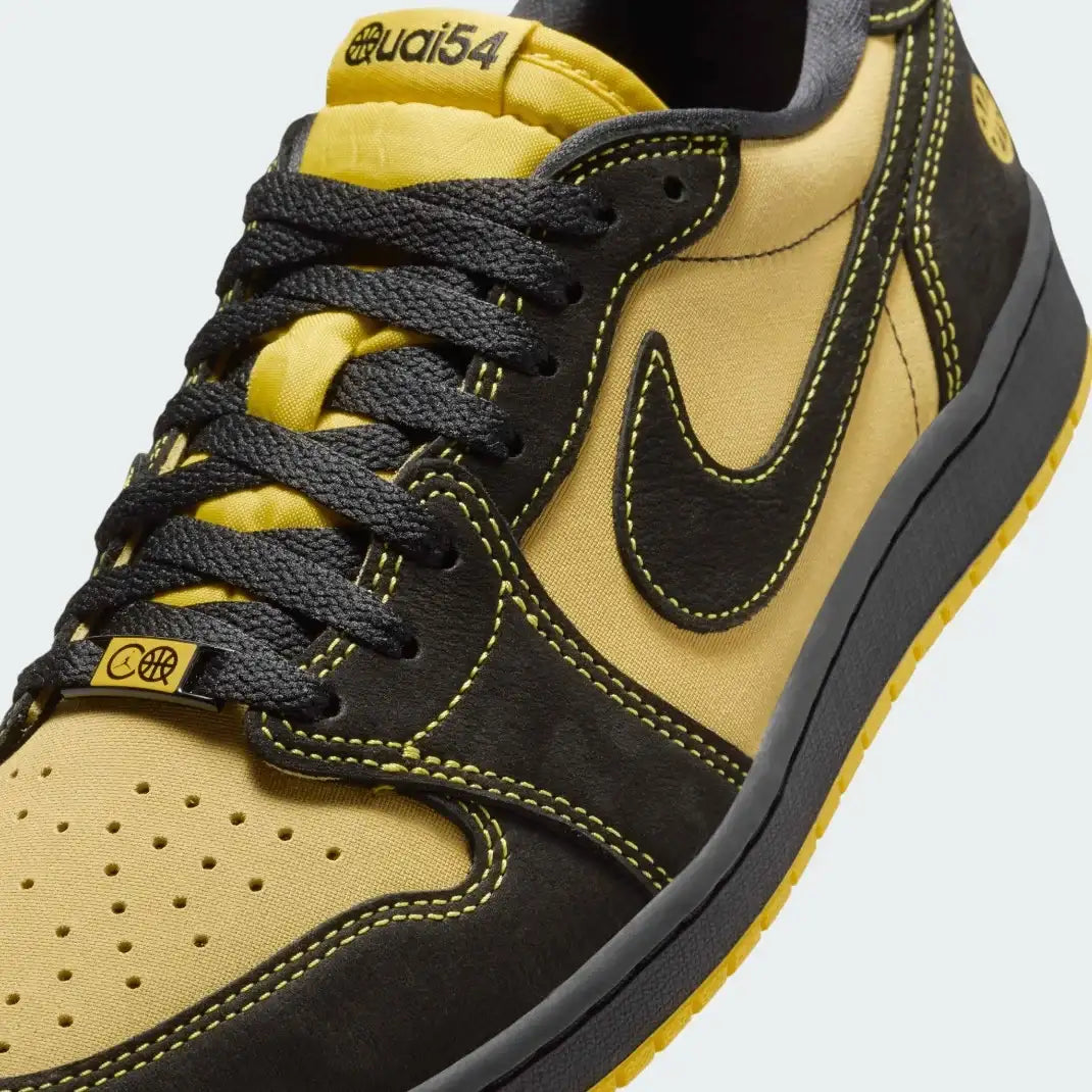 Close-up zoom on the front of the Air Jordan 1 Retro Low OG Q54 men's trainers, showing the perforated toe box, lacing system, and textured leather upper.