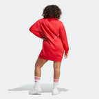 back profile modern worn of the Adidas Archival Oversize Dress in Better Scarlet red, showing the long sleeves, ribbed cuffs, and the relaxed, modern silhouette.