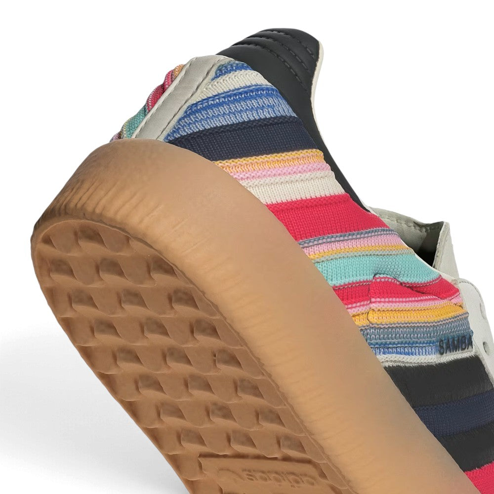 Zoom Looking at the Outsole and Midsole: Detailed close-up angle capturing the textured sidewall profile of the gum rubber platform midsole meeting the striped textile quarter panel.   