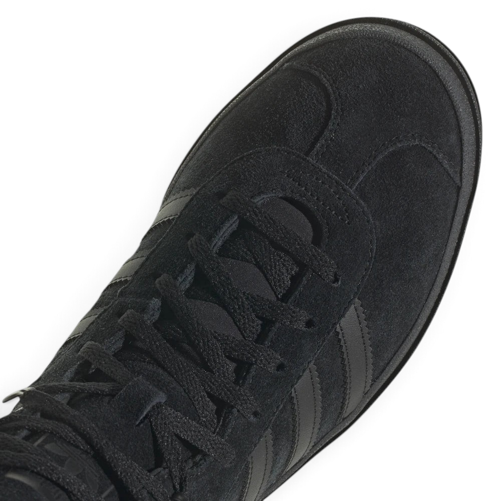 Details the high-definition finish of the suede T-toe overlay and the premium quality of the black eyelets.