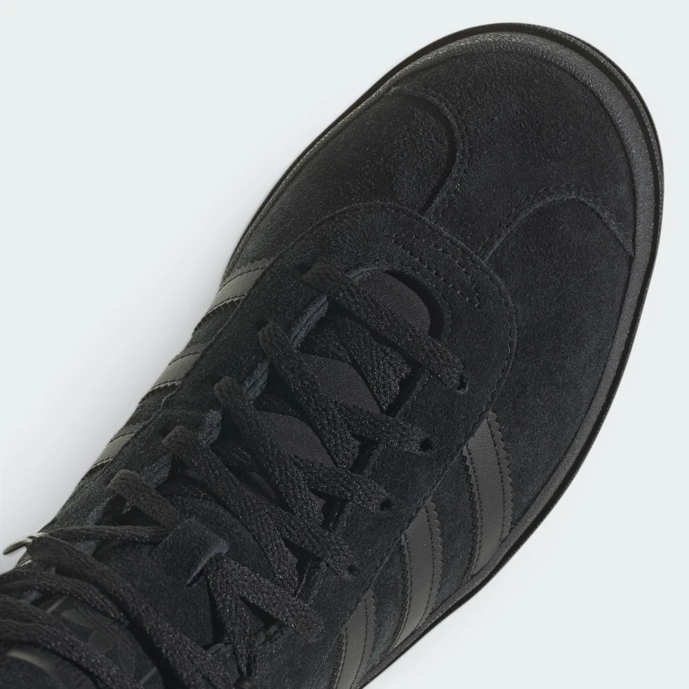 Details the high-definition finish of the suede T-toe overlay and the premium quality of the black eyelets.