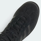 Details the high-definition finish of the suede T-toe overlay and the premium quality of the black eyelets.