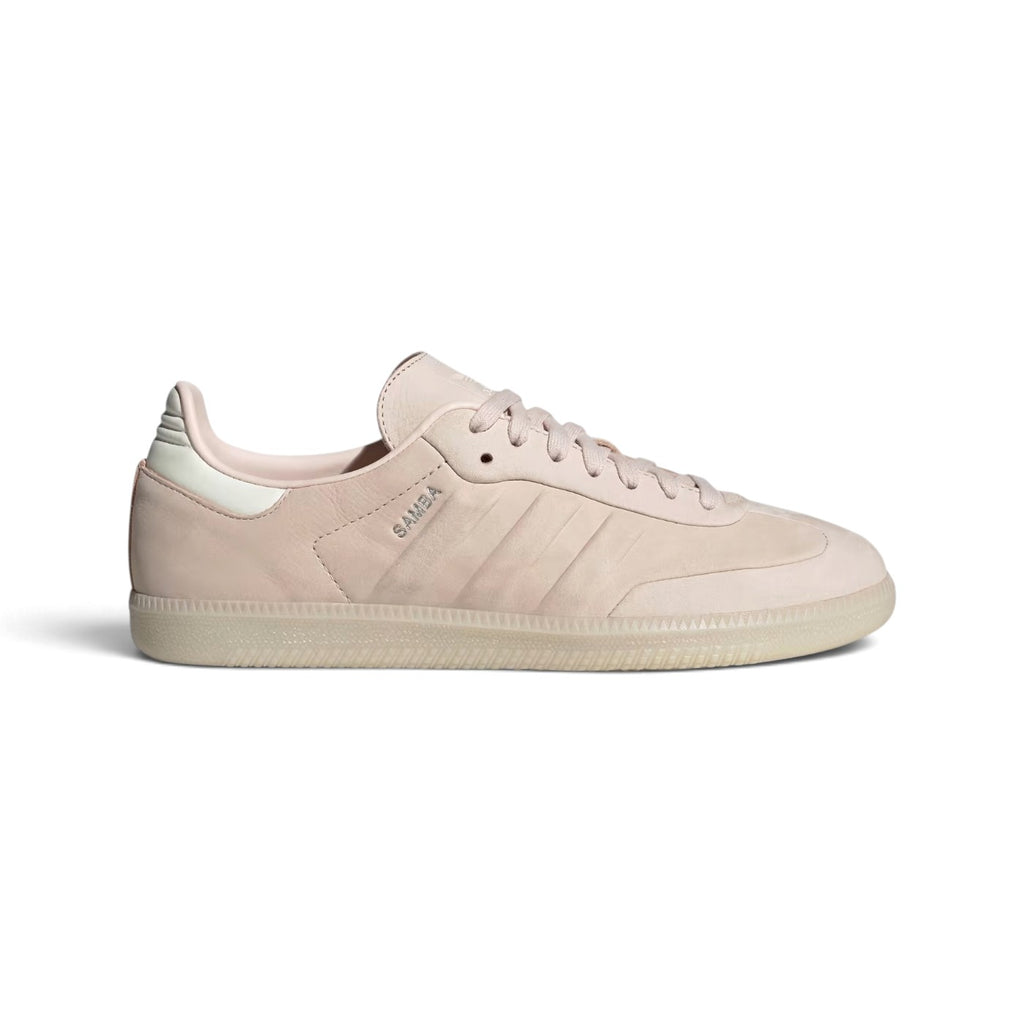Side Profile Image: Studio lateral shot of the minimalist adidas Samba in soft tonal pink, highlighting the smooth leather upper, subtle debossed three stripes, silver foil SAMBA lettering, and translucent gum rubber outsole.   