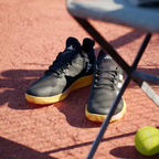 Angled shot of both Adizero Ubersonic 4.1 shoes, showcasing the sleek, modern silhouette and the metallic branding details.