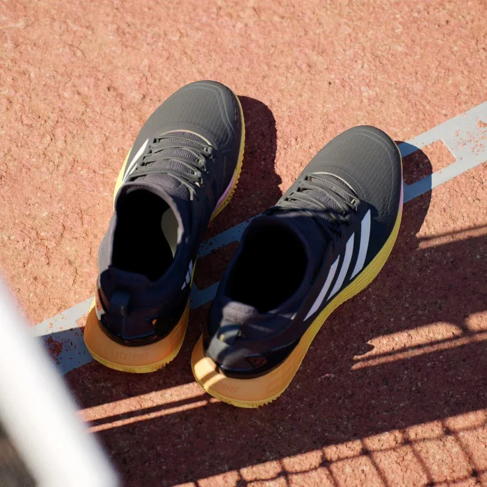 Top-down view of the black clay tennis shoes, highlighting the reinforced mesh upper and the integrated sock-like lacing system.