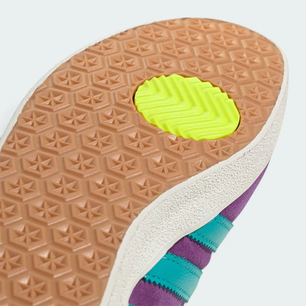 Close-up of a shoe sole with a textured pattern and a bright yellow heel counter on a white background.