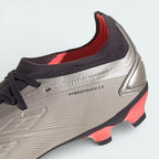 Detailed zoom on the edge of the outsole and midsole area, highlighting the metallic finish and the durable construction of the multi-ground studs.
