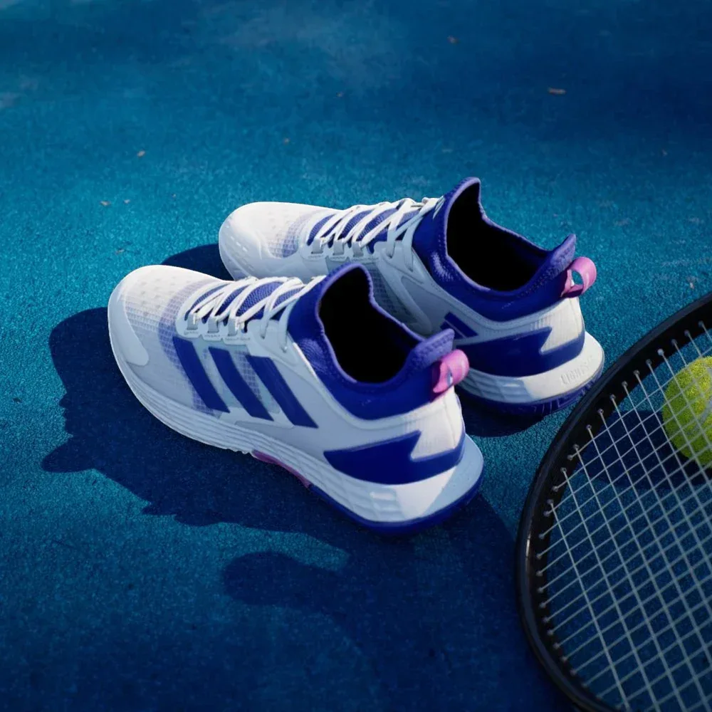 Top-down view of the tennis shoes, highlighting the breathable white mesh, integrated lacing system, and the sock-like collar.