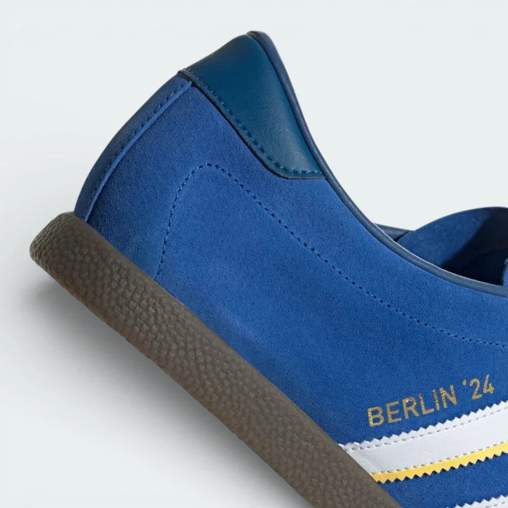 Detailed zoom on the junction between the blue suede upper and the gum rubber sole, showing the high-quality German construction.