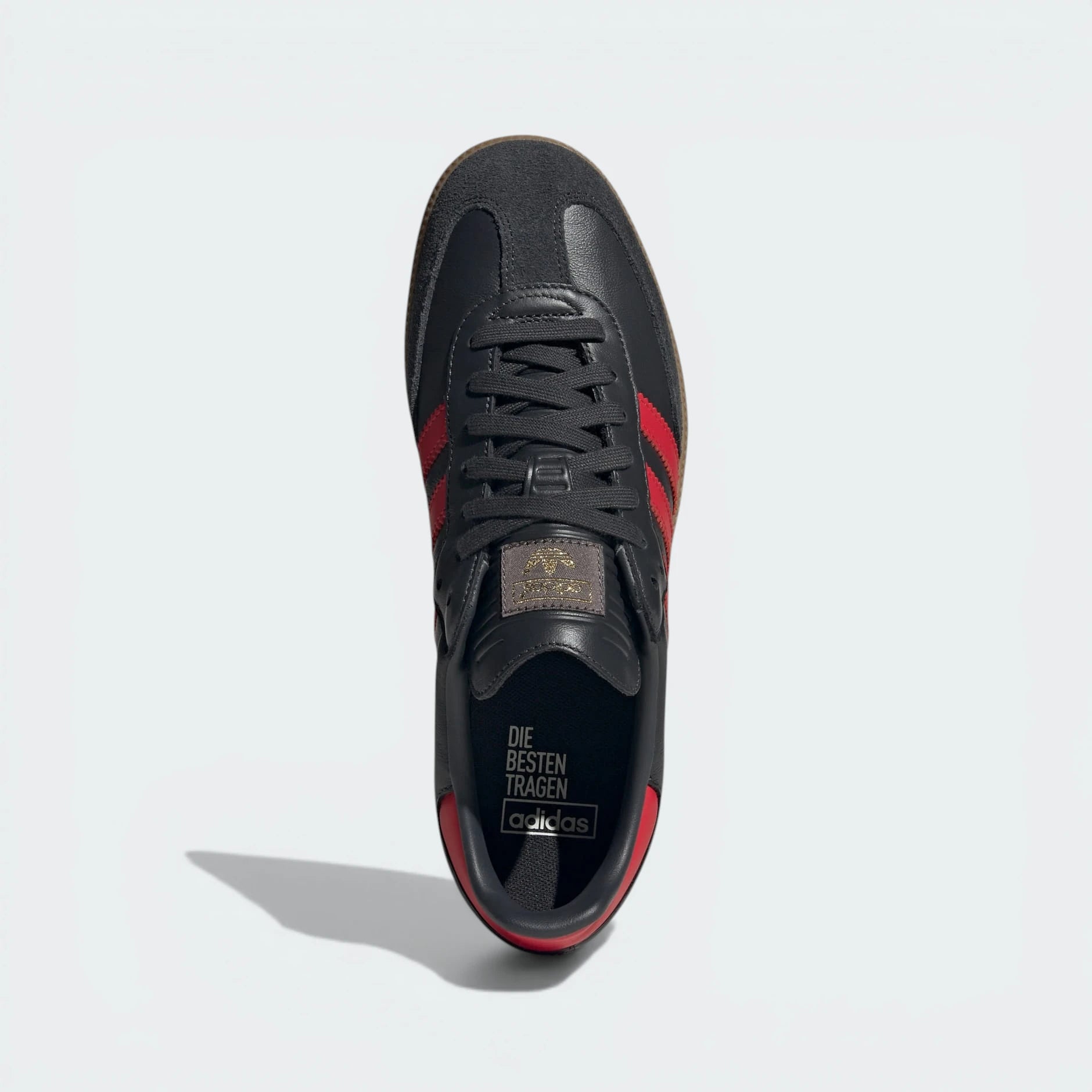 Looking down at the carbon grey lacing system and the blue Trefoil logo branding on the tongue.