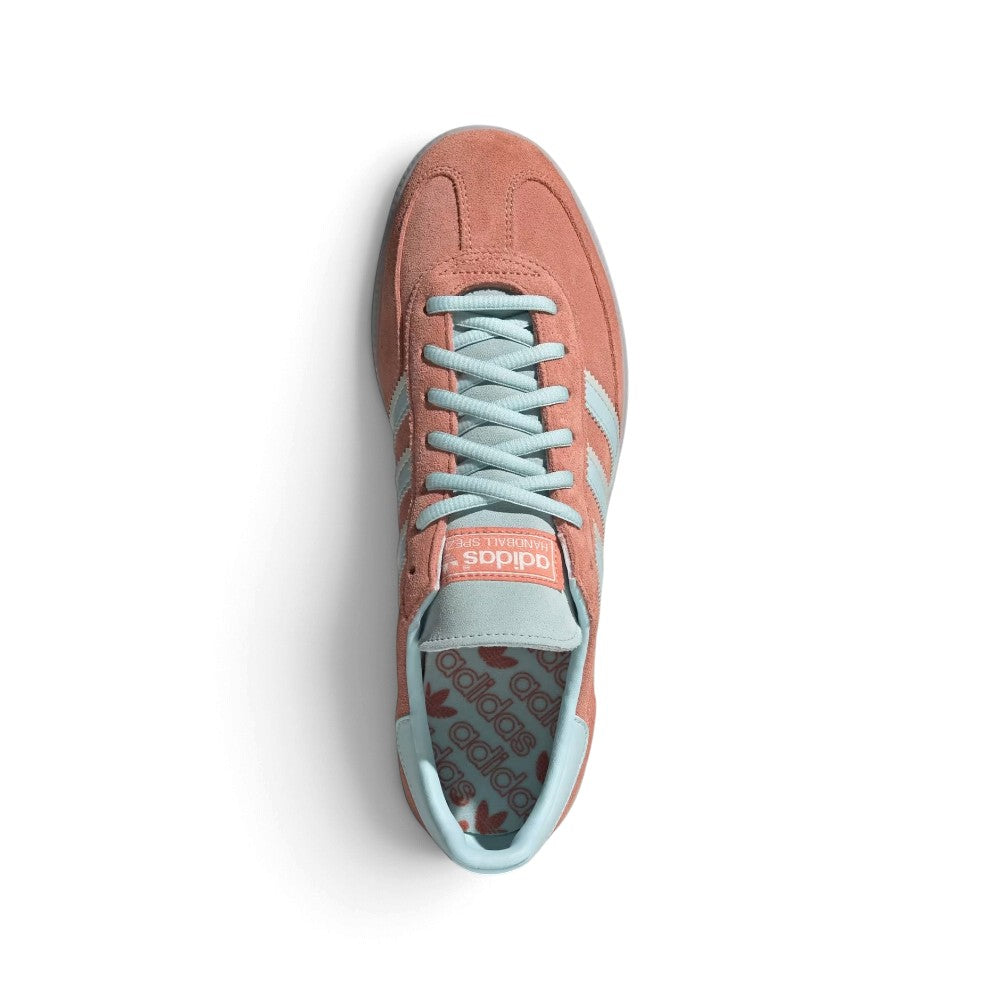 Top-Down View of Pair/Item: Overhead view looking down at the laced pink shoes, displaying the pale blue flat laces, tongue label with embossed adidas Trefoil branding, and the printed graphic insole.   