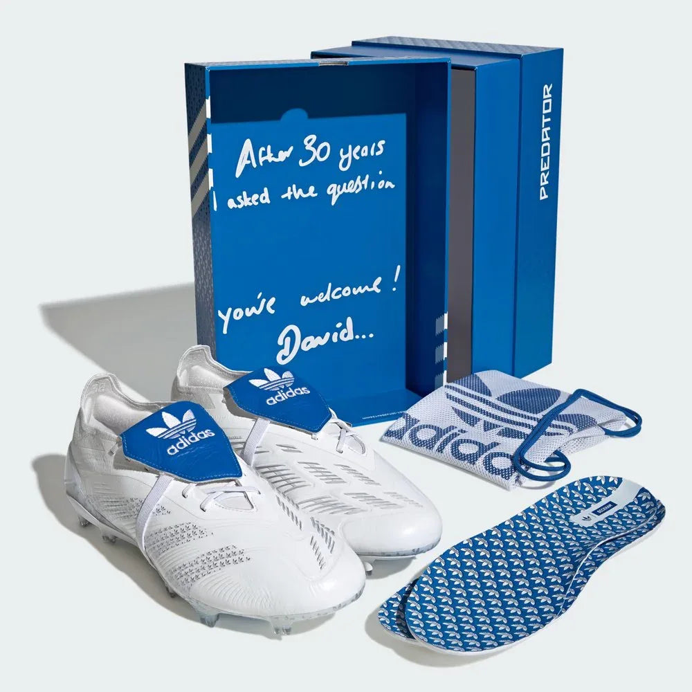White Adidas soccer shoes with blue packaging and insoles on a white background
