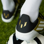 Rear view focusing on the structured heel cup and the signature Messi logo detail in Core Black.