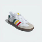 White Adidas sneaker with colorful stripes on a light gray background