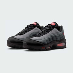 Angled view of two Nike Air Max 95 OG Men's running shoes in black and crimson red, side by side, showcasing their timeless design and layered upper.