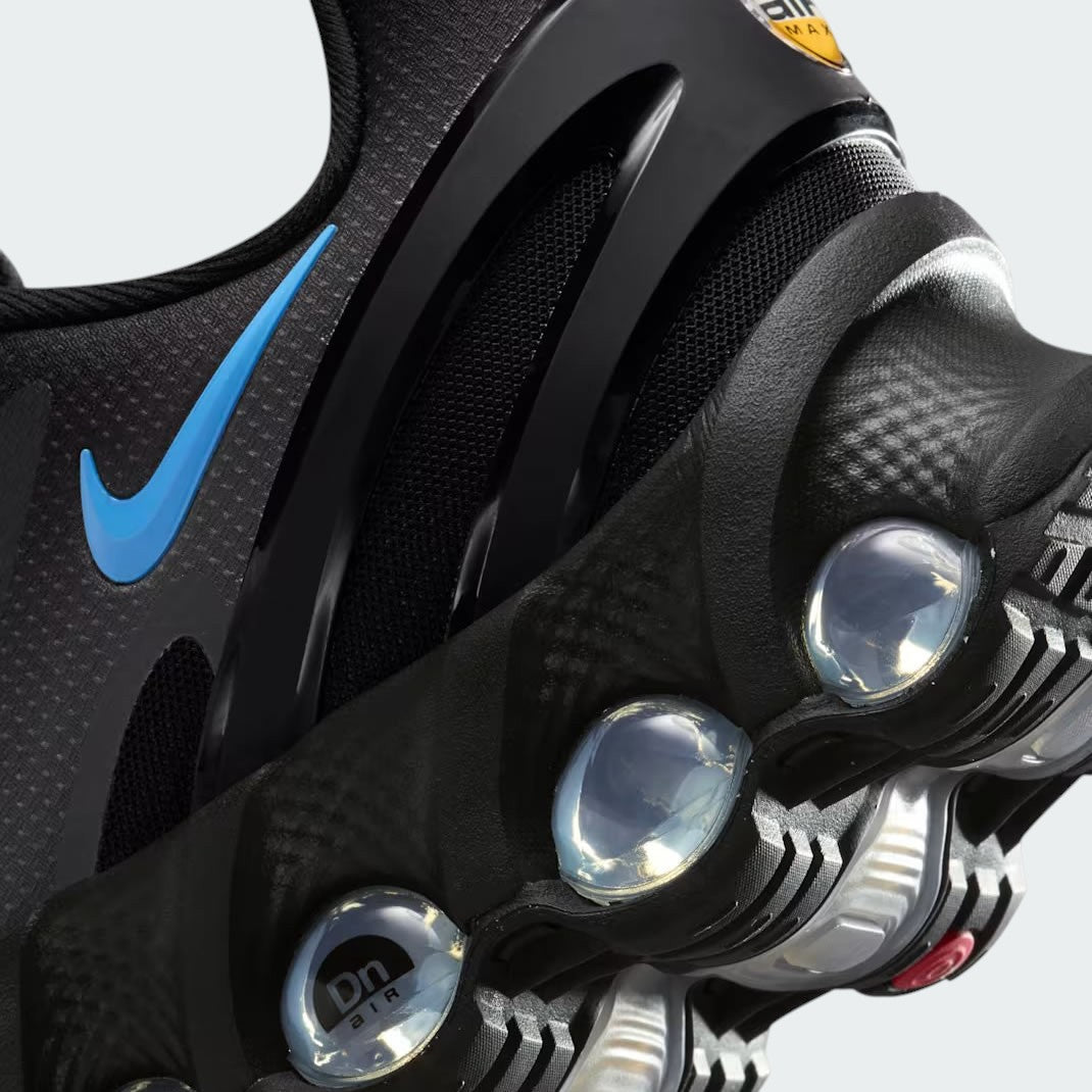 Detailed zoom on the outsole and midsole of the Nike Air Max DN Men's black running shoes, highlighting the dual-pressure Dynamic Air cushioning system and robust rubber outsole.